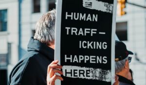 Man holding "Human trafficking happens here" sign