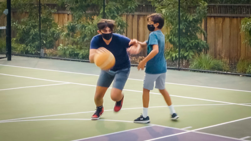 Mentor and kid playing basketball
