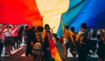 Running in street with LGBTQ Pride flag