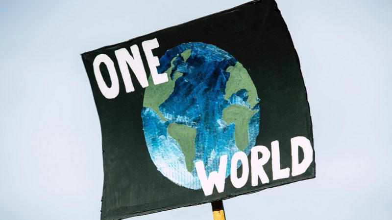 "One World" protest sign