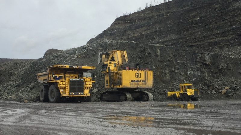 A photo of three mining vehicles parking at the coal mine