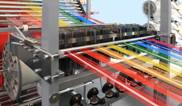 Multi-colored yarns in the textile machine stock photo