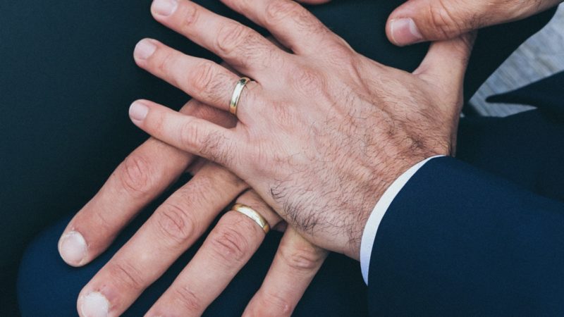 Two men's hands with rings on them