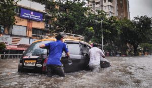 People pushing car in flood