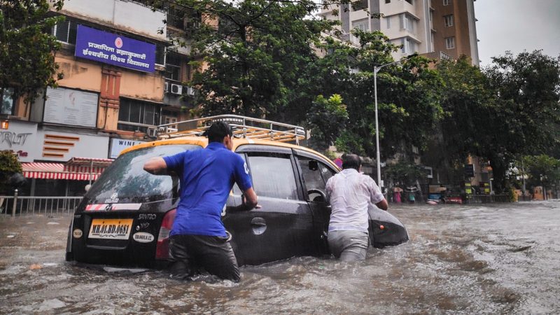 People pushing car in flood