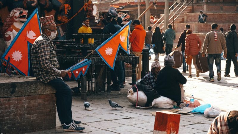 Man holding Nepali flag in a crowd