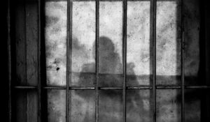 A shadow of a person beyond bars