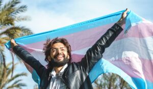 Person happily holding a trans pride flag