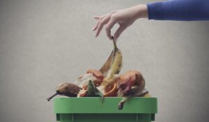 Woman putting organic waste in the compost bin