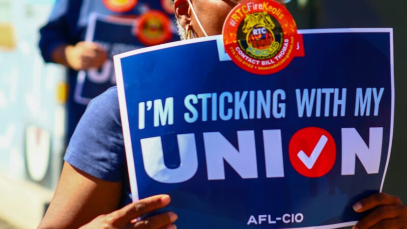 Person holding "I'm sticking with my union" sign
