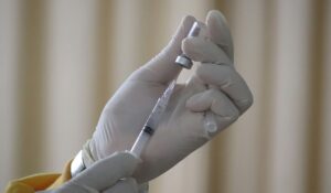 Person filling syringe with vaccine