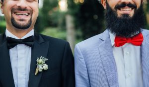 Two smiling men in wedding suits